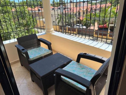 a balcony with a table and two chairs and a window at Comfortable and cute in Santo Domingo