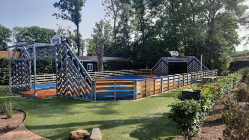a wooden bridge in the middle of a yard at Das Holland Beachhouse, modern eingerichtet, in schöner Lage am Veluwemeer, inklusive Garten, Terrasse am Wasser, Parkplatz und WLAN in Hulshorst