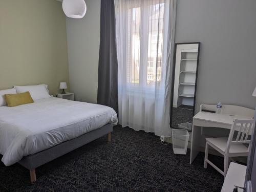 een slaapkamer met een bed, een bureau en een wastafel bij Hôtel Le Millésime in Meymac