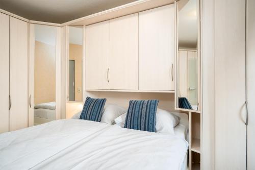 Schlafzimmer mit einem Bett und weißen Schränken in der Unterkunft LIN 002 - Seepark in Scharbeutz