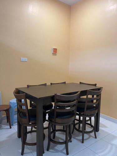 uma mesa de jantar com quatro cadeiras à volta em C & L Home 002 em Keluang