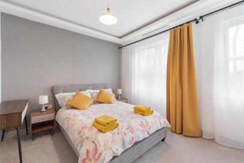 a bedroom with a bed with yellow towels on it at The Pearl - Luxury 5* Home with Park View in London