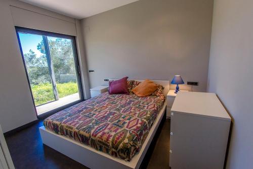 een kleine slaapkamer met een bed en een raam bij Catalunya Casas Modern Hilltop Haven with private pool 7km to beach in Castellet