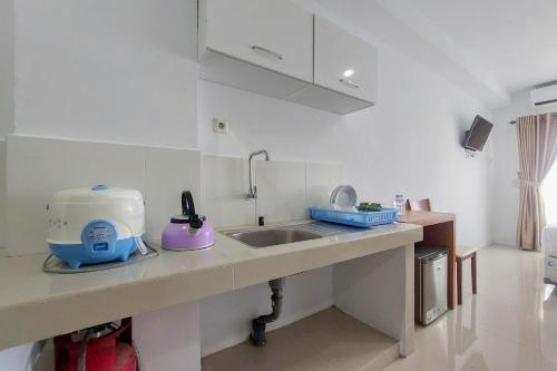 uma cozinha com um lavatório e uma mesa de mistura num balcão em Brand New and Nice Studio at Skyview Medan Apartment By Travelio em Sunggal