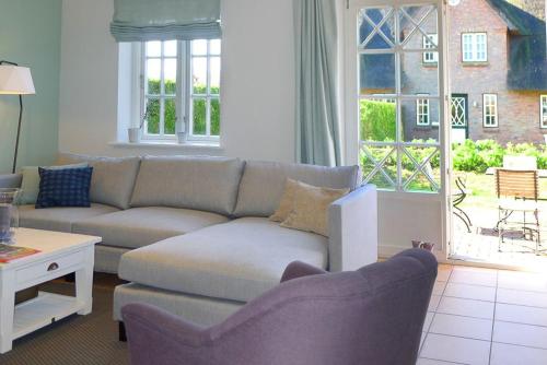 Alkersum的住宿－Haus Weitblick，带沙发和窗户的客厅