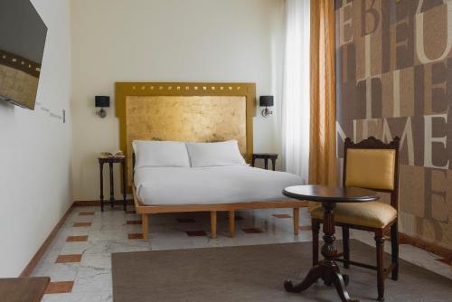 1 dormitorio con 1 cama, 1 mesa y 1 silla en Al Ponticello, en Comacchio