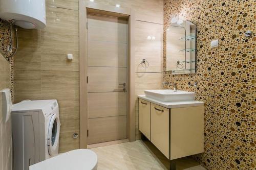 a bathroom with a sink and a washing machine at Stylish spacious apartment near the sea in Budva