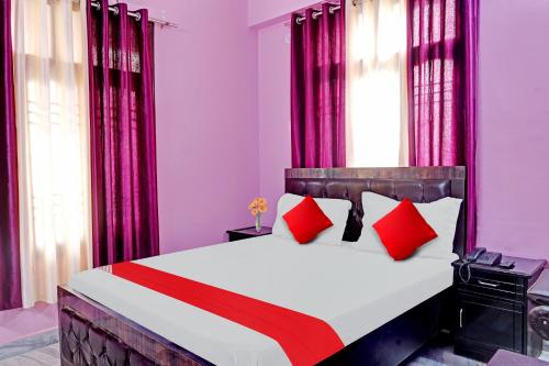 um quarto com uma cama grande e almofadas vermelhas em Flagship Hotel The Pinkcity em Patna