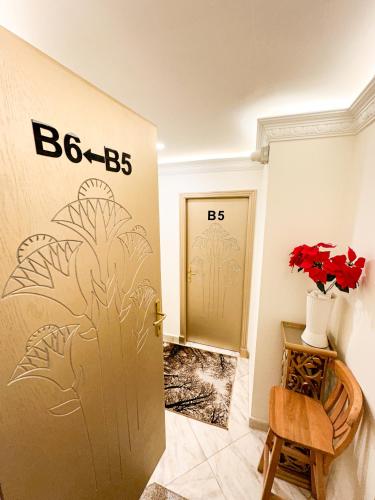a room with a door and a vase of flowers at Afnan Cairo Airport in Cairo