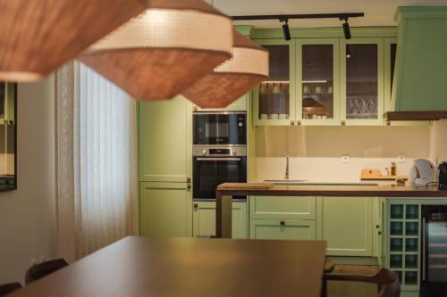 a kitchen with green cabinets and a wooden table at Feel Discovery Casal do Temporao Douro Valley in Peso da Régua