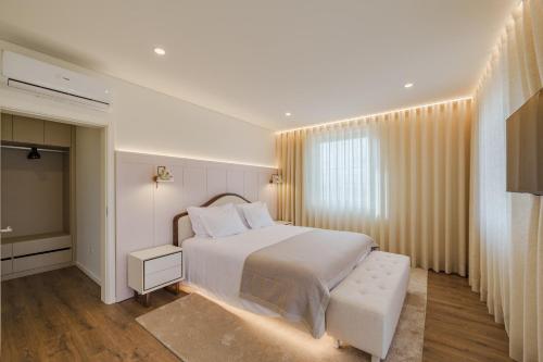 a bedroom with a white bed and a window at Feel Discovery Casal do Temporao Douro Valley in Peso da Régua
