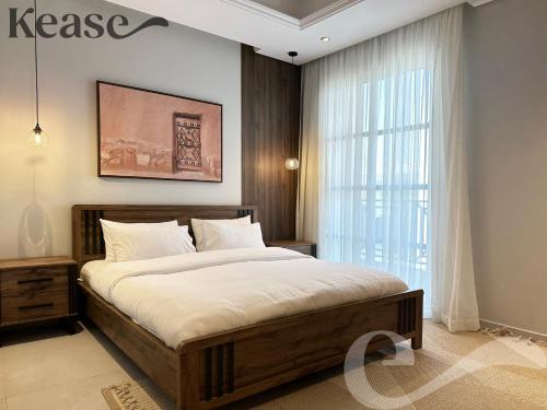 ein Schlafzimmer mit einem großen Bett und einem großen Fenster in der Unterkunft Kease Hittin N-14 Lusso Hejaz Balcony & Terrace AZ76 in Riad