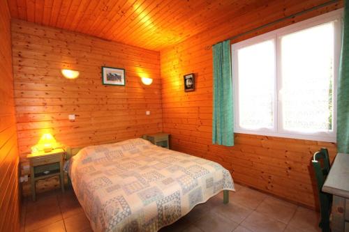 ein Schlafzimmer mit einem Bett in einem Holzzimmer in der Unterkunft GASPRO23 - Golfe de St-Tropez - Maison californienne pour 6 personnes dans domaine privé in Gassin