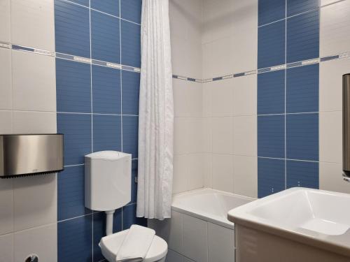 ein Badezimmer mit einem weißen WC und einem Waschbecken in der Unterkunft OSIJEK SPACE CENTAR - Free self check in, Free private parking in Osijek