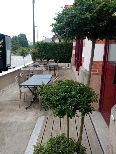 a row of tables and chairs on a sidewalk at Hôtel Le Millésime in Meymac