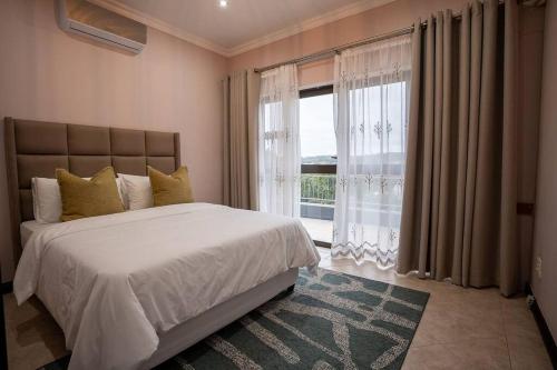 - une chambre avec un grand lit et une grande fenêtre dans l'établissement Entire Home in Sheffield Beach, à Sheffield Beach