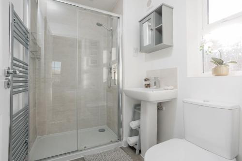 a white bathroom with a shower and a sink at Ballard House in Swanage