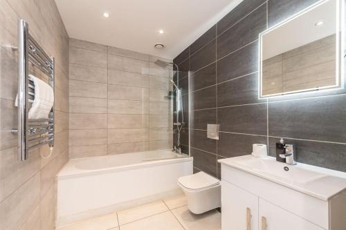 a bathroom with a toilet and a tub and a sink at Studio Apartment in Liverpool City Centre in Liverpool