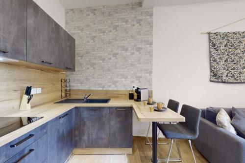 une cuisine avec des placards bleus et une table avec des chaises dans l'établissement Suite Stars FSHH, à Nice