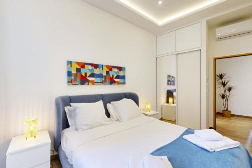 - une chambre avec un grand lit blanc et une couverture bleue dans l'établissement Suite Stars FSHH, à Nice