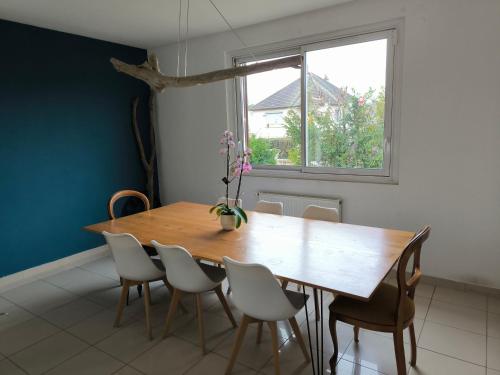 ein Esszimmer mit einem Holztisch und Stühlen in der Unterkunft Chambre d'hôte proche de la nature in Lamorlaye