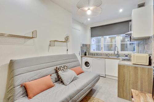 a living room with a couch and a kitchen at 143 Suite La Française Superbe Appartement à Paris in Paris