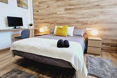 a bedroom with a bed with two pairs of shoes on it at apartamento premium muy cerca ciudad Barcelona in Badalona