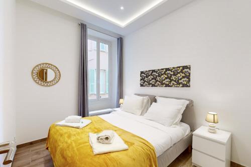 une chambre blanche avec un grand lit avec une couverture jaune dans l'établissement Suite Gold-Stars FSHH, à Nice