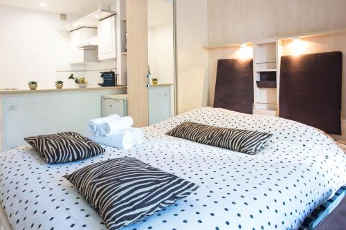 uma cama com almofadas de zebra num quarto em COSY STUDIO - Résidence front de mer - Menton em Menton