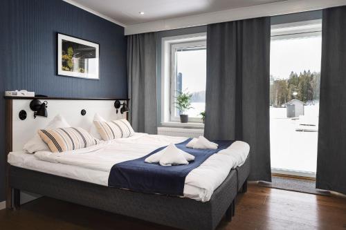 um quarto com uma cama grande e paredes azuis em Lakelodge em Karlskoga