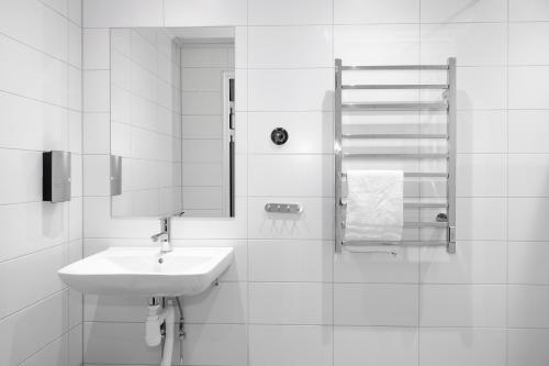 bagno bianco con lavandino e specchio di Lakelodge a Karlskoga