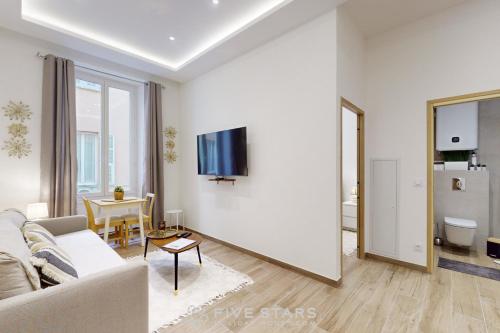 un salon avec un canapé et une télévision sur un mur dans l'établissement Suite Gold FSHH, à Nice