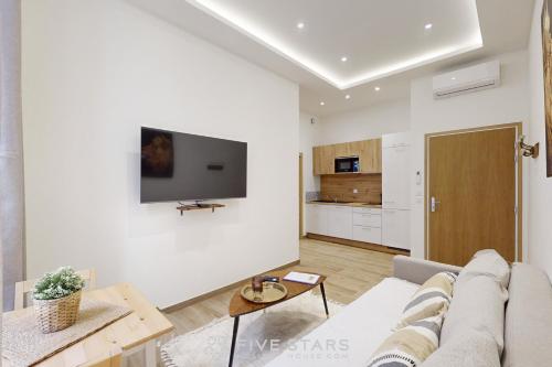 un salon avec un canapé et une télévision sur un mur dans l'établissement Suite Gold FSHH, à Nice