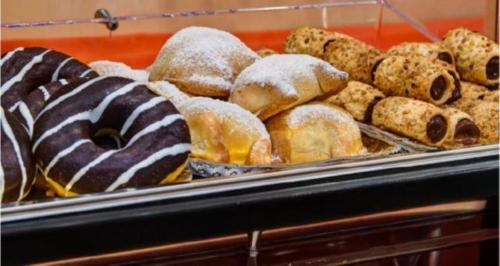 a display case of different types of donuts and pastries at Best Western Hotel La Solara in Sorrento