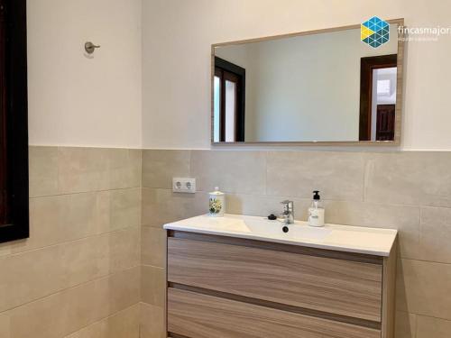 ein Bad mit einem Waschbecken und einem Spiegel in der Unterkunft Cas rellotger country house in Llucmajor