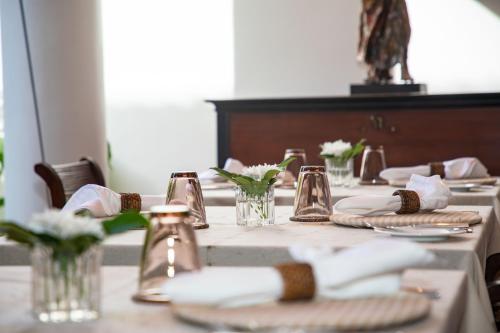 a table with plates and glasses and flowers on it at Nyne Hotels Landesi - Galle Fort in Galle