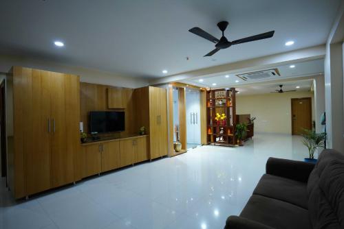 Happy Nest Guest Home في Kurmannapalem: غرفة معيشة مع أريكة ومروحة سقف