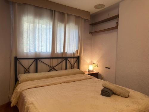 a bedroom with a large bed with a window at La casa de Lili acerca de palacio de música in Valencia