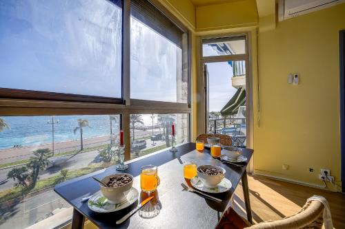 une salle à manger avec une table avec vue sur l'océan dans l'établissement Maison Bianchi - 187 Promenade des Anglais - Sea view, à Nice