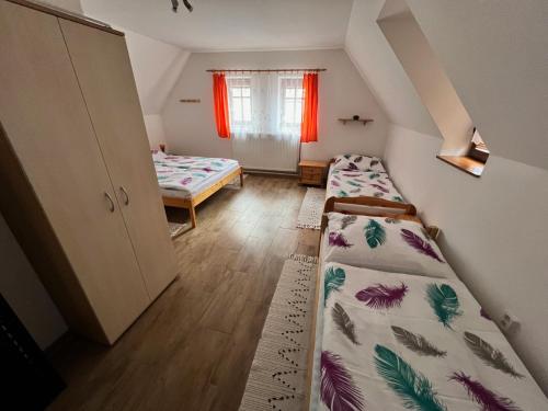 a small room with two beds and a window at rekreační dům Pohoda in Jiřetín pod Jedlovou