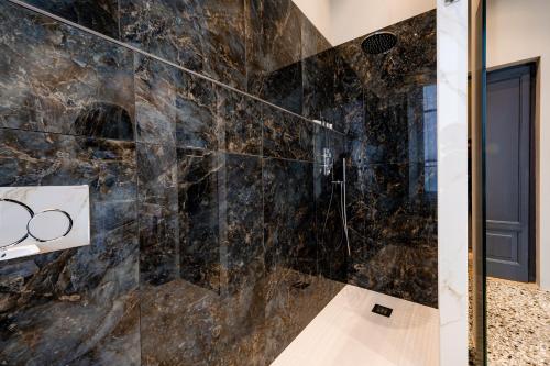 bagno con box doccia in marmo nero. di Exclusive Room Pescara a Pescara