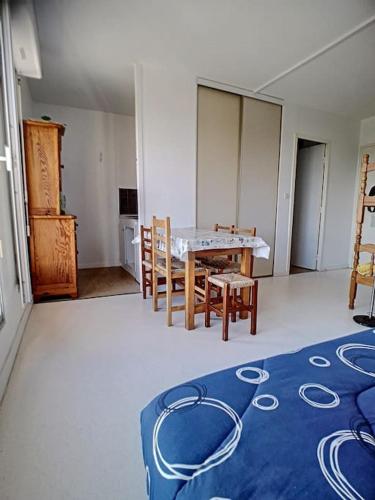 Cette chambre comprend une table, des chaises et un tapis bleu. dans l'établissement Studio dans une résidence - S04201, à Soulac-sur-Mer