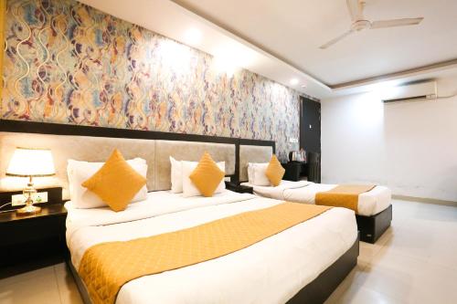 a hotel room with two beds and a painting on the wall at Hotel Aashiyana New Delhi in New Delhi