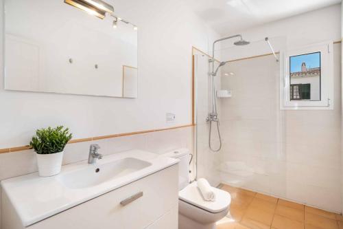Un baño blanco con lavabo y ducha. en Sa Lluna Galdana, en Cala Galdana