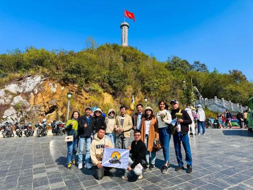 un groupe de personnes posant une photo devant une colline dans l'établissement Ti Lau Homestay & Motorbikes, à Ha Giang