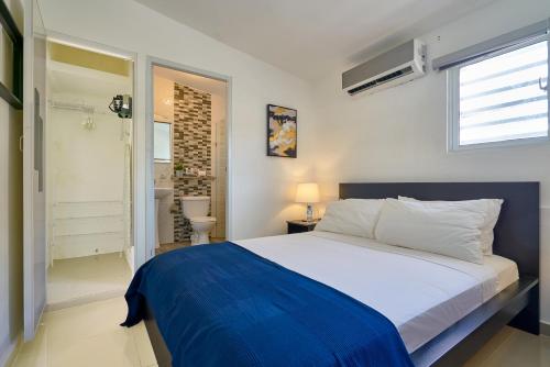 a bedroom with a large bed and a bathroom at Escape Studio Close to Agora Mall in Santo Domingo