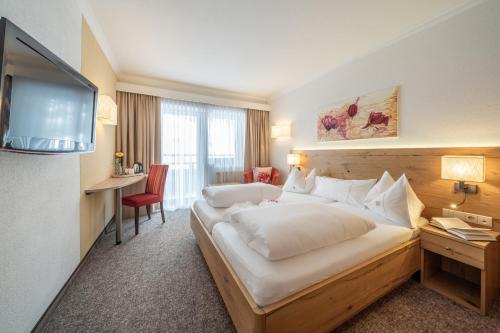 a hotel room with a bed and a television at Hotel Madeleine in Obergurgl