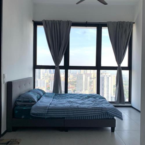 uma cama num quarto com uma grande janela em Urban Suite Penang Homestay 1B em Jelutong