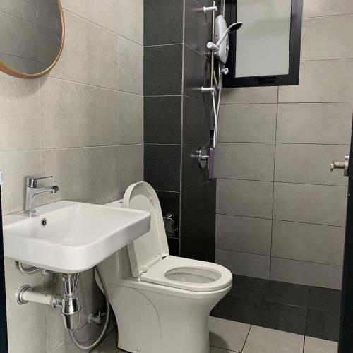 uma casa de banho com um WC branco e um lavatório. em Urban Suite Penang Homestay 1B em Jelutong