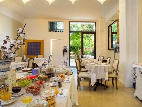 una sala da pranzo con tavoli e sedie con cibo sopra di Gagliardi Boutique Hotel a Noto